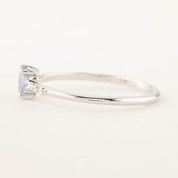 Side view of a 0.45ct unheated oval sapphire set in 14k gold with a sparkling diamond pave band.