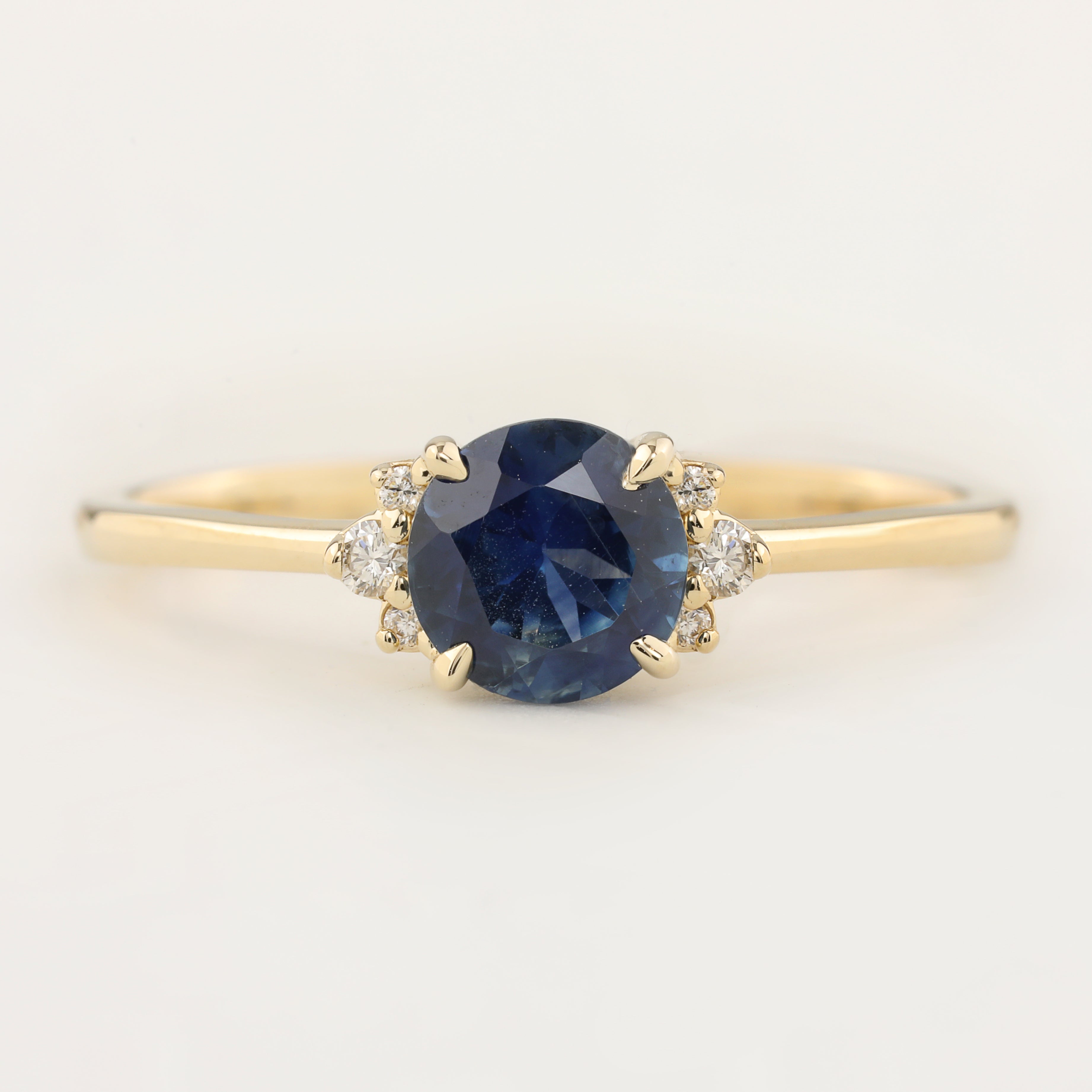 Stunning Lena Ring featuring a 1.18ct blue Montana sapphire, set in 14k yellow gold with sparkling diamond accents.